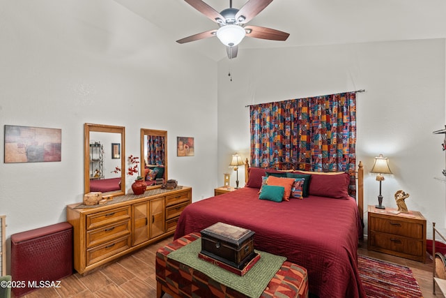 bedroom featuring ceiling fan, high vaulted ceiling, and wood finished floors