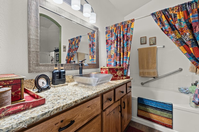 bathroom with vanity and lofted ceiling