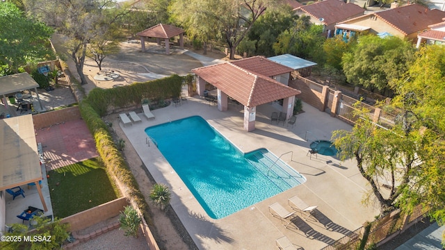 community pool with a patio, a gazebo, and fence