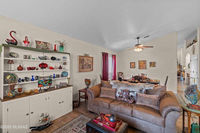 living area with lofted ceiling, dark wood-style flooring, visible vents, and ceiling fan