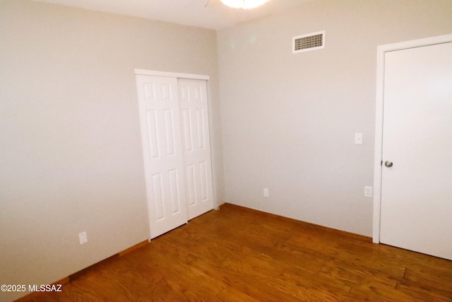 unfurnished bedroom with visible vents and wood finished floors