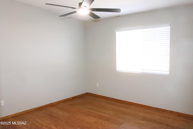 empty room featuring a ceiling fan, light wood-style flooring, and baseboards