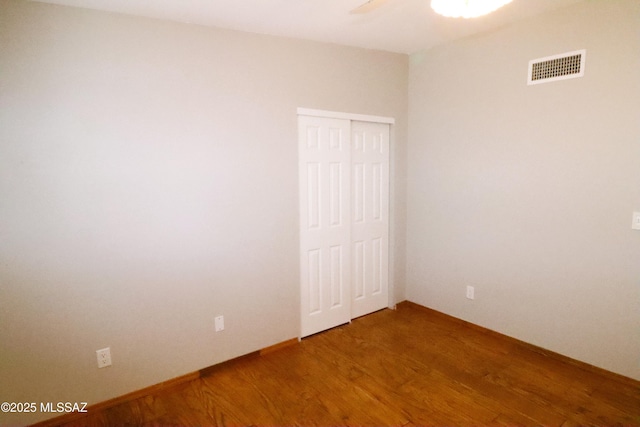 spare room with light wood-type flooring, baseboards, ceiling fan, and visible vents