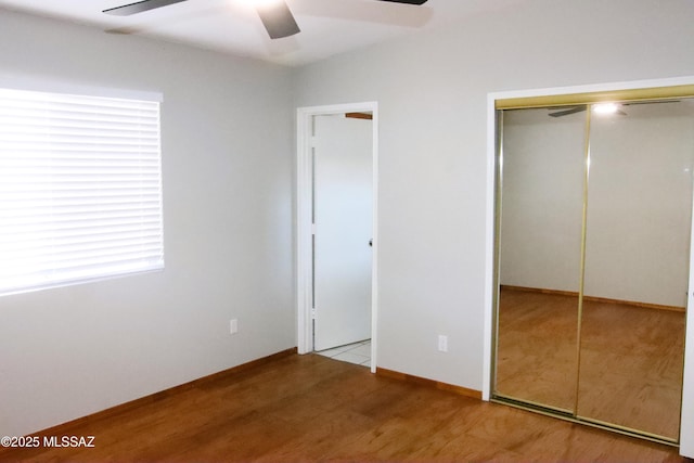 unfurnished bedroom featuring baseboards, light wood-style floors, and ceiling fan