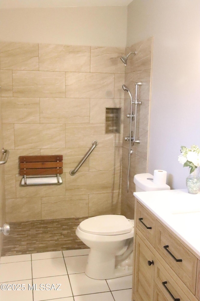 full bath with a tile shower, toilet, tile patterned floors, and vanity