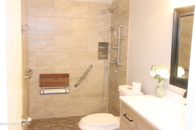 full bathroom featuring toilet, tiled shower, and vanity
