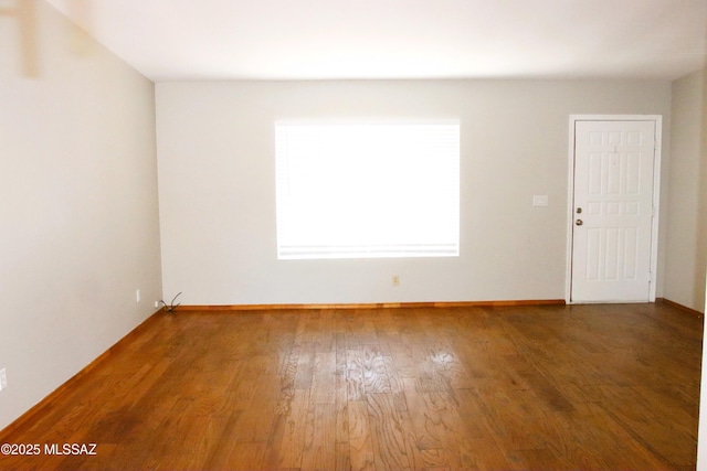unfurnished room featuring baseboards and wood finished floors