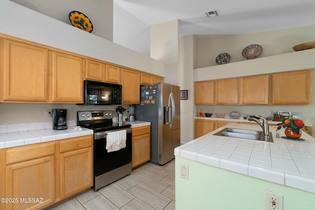 kitchen featuring visible vents, a sink, light countertops, appliances with stainless steel finishes, and high vaulted ceiling