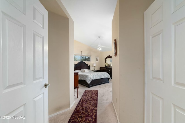 hall with arched walkways, baseboards, lofted ceiling, and carpet