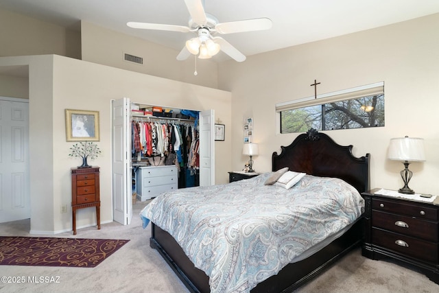 bedroom featuring a closet, vaulted ceiling, a ceiling fan, visible vents, and light colored carpet