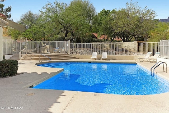 pool with a patio and fence