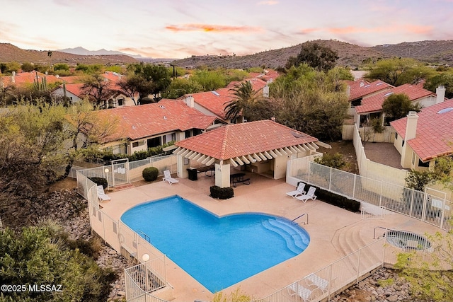 community pool with a mountain view, a pergola, fence, and a patio area