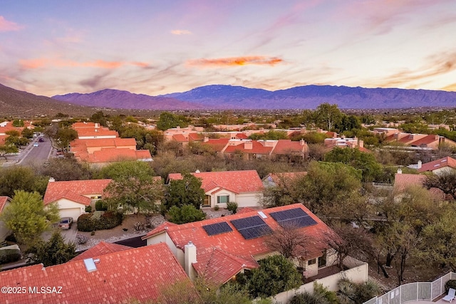 aerial view at dusk featuring a mountain view and a residential view