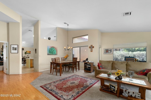 living area featuring visible vents, a chandelier, and wood finished floors