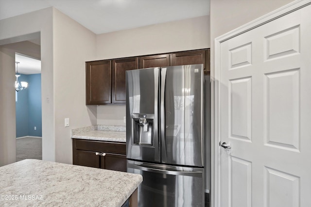 12272 W Reyher Farms Loop, Marana, AZ 85653 - kitchen with stainless steel fridge with ice dispenser, dark brown cabinets, light countertops, and a chandelier