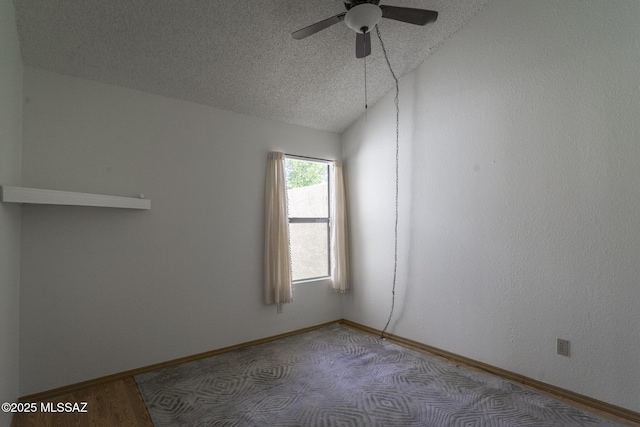 empty room featuring a textured ceiling, vaulted ceiling, baseboards, and a ceiling fan