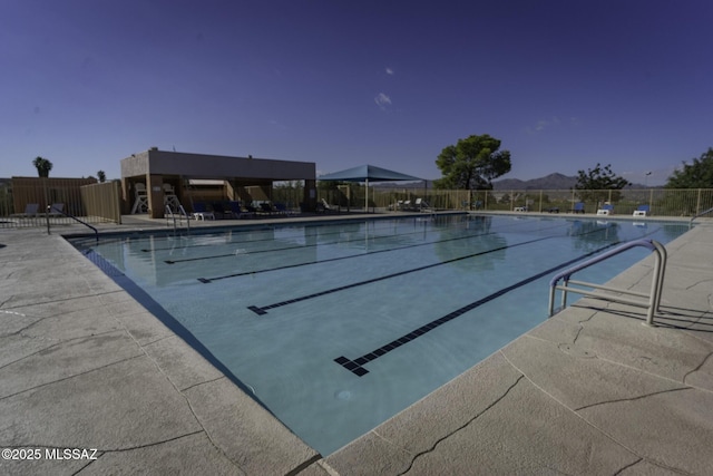 pool featuring fence and a patio