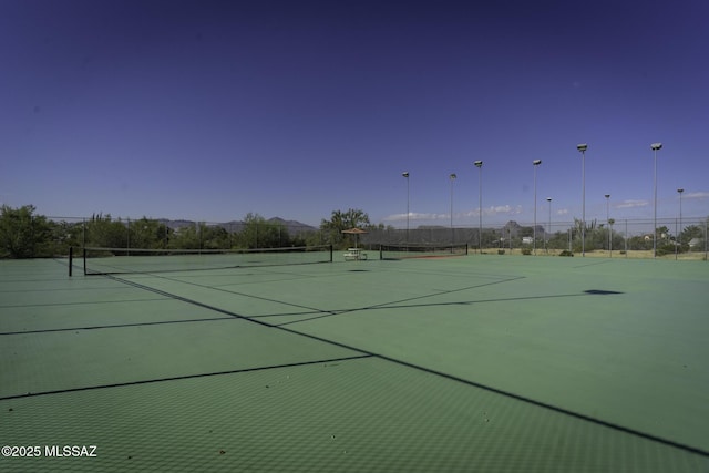 view of tennis court featuring fence
