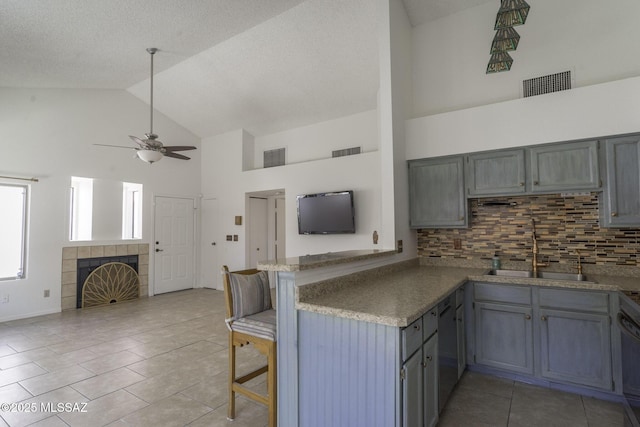 kitchen featuring a sink, a ceiling fan, visible vents, and a peninsula