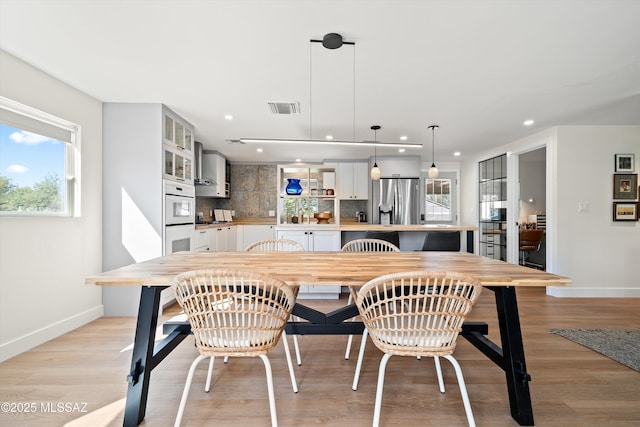 dining area with visible vents, baseboards, and a wealth of natural light