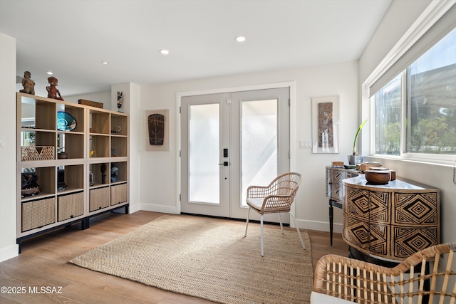 interior space featuring baseboards, french doors, wood finished floors, and recessed lighting