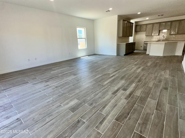 5448 W Summer View Dr, Marana, AZ 85658 - unfurnished living room featuring dark wood-style flooring, a sink, recessed lighting, and baseboards