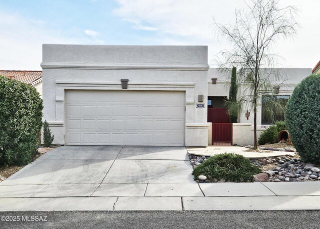 view of front of house featuring stucco siding, driveway, and a garage
