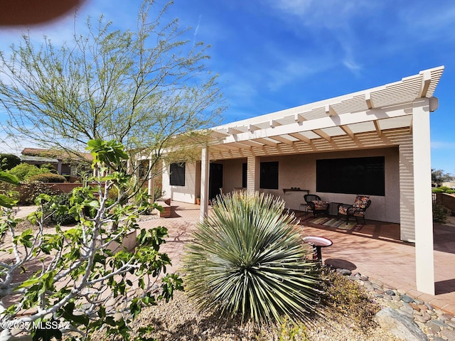 back of house featuring a pergola, stucco siding, and a patio area