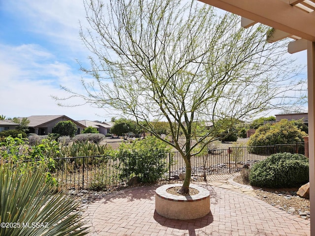 view of patio featuring an outdoor fire pit and fence
