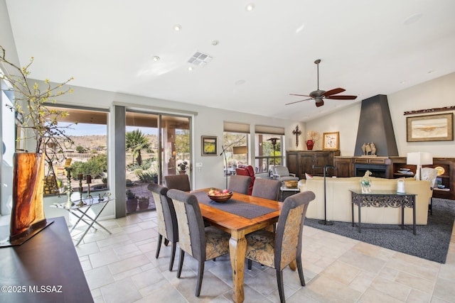 dining room with lofted ceiling, visible vents, and ceiling fan
