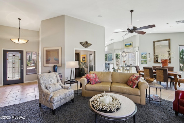 tiled living area with visible vents, a ceiling fan, high vaulted ceiling, and baseboards