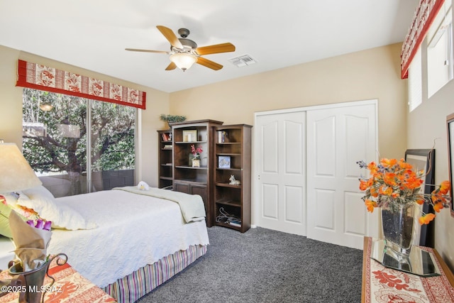 carpeted bedroom featuring visible vents, ceiling fan, multiple windows, and a closet