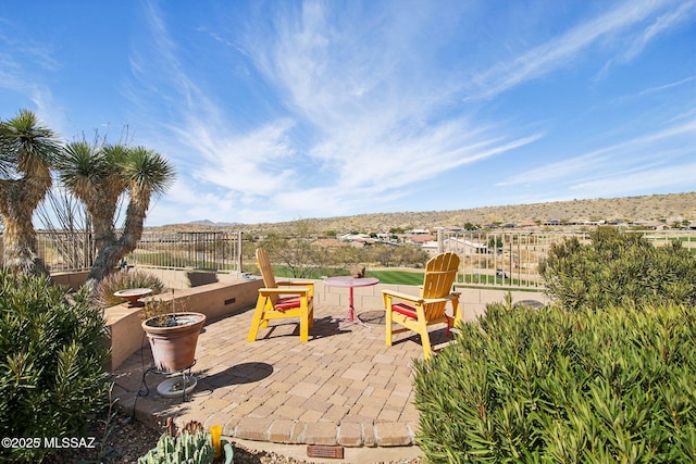 view of patio / terrace featuring a mountain view and fence