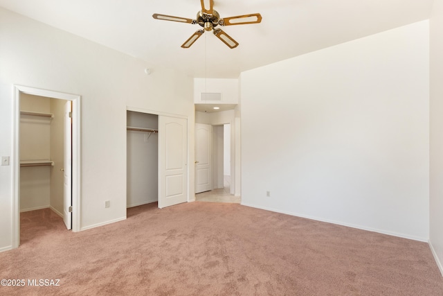 unfurnished bedroom featuring light carpet, baseboards, visible vents, and ceiling fan