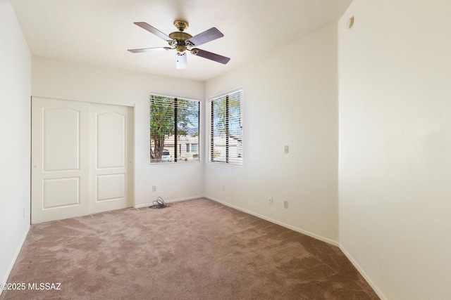 unfurnished bedroom featuring carpet flooring, a ceiling fan, baseboards, and a closet