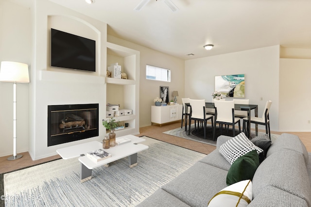 tiled living area featuring a glass covered fireplace