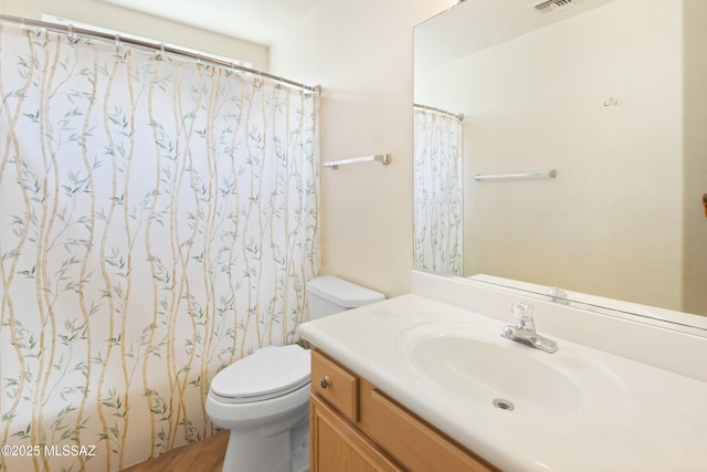 full bath featuring toilet, vanity, curtained shower, and visible vents