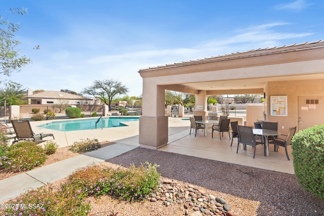 view of swimming pool with a fenced in pool, outdoor dining area, fence, and a patio