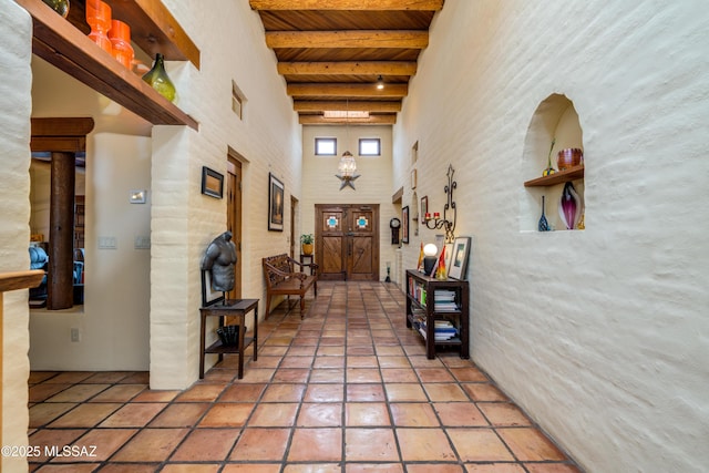 corridor with wood ceiling, beam ceiling, and a towering ceiling