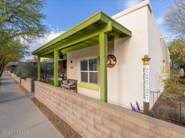 view of home's exterior with fence and stucco siding