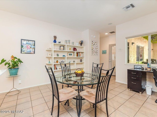 dining room featuring light tile patterned floors, visible vents, and baseboards