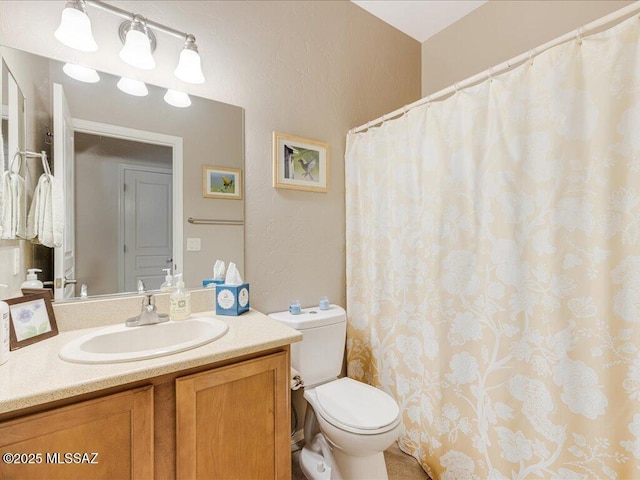 bathroom featuring vanity, toilet, a textured wall, and curtained shower