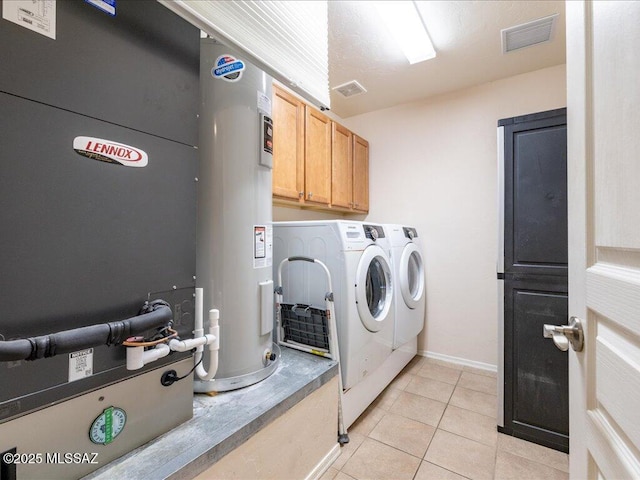 clothes washing area featuring cabinet space, washing machine and clothes dryer, light tile patterned flooring, visible vents, and water heater