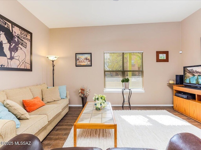 living area featuring baseboards and wood finished floors