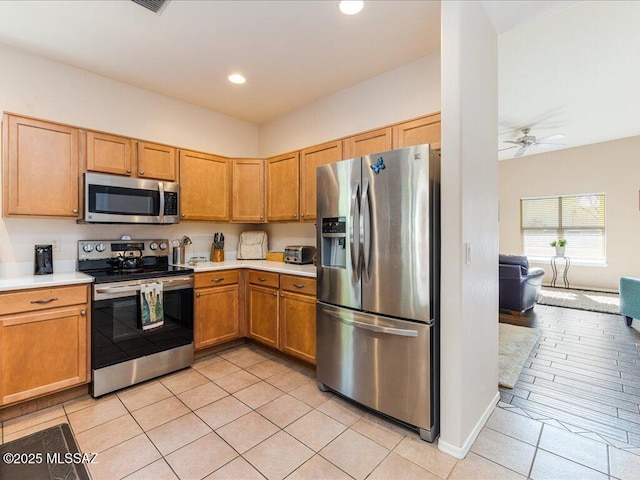 kitchen with recessed lighting, stainless steel appliances, light tile patterned floors, a ceiling fan, and light countertops