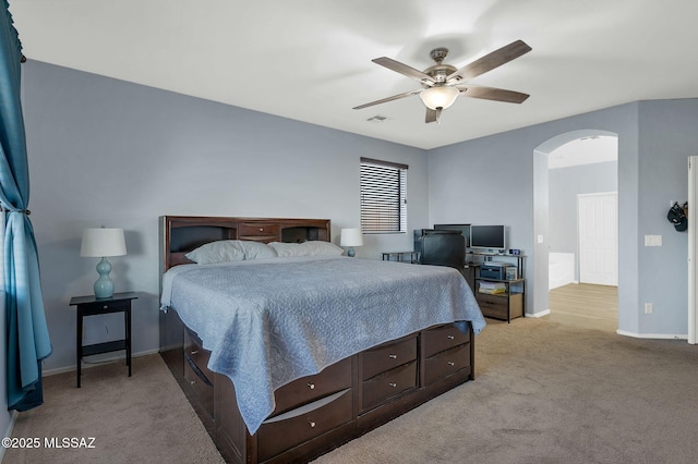 bedroom featuring arched walkways, visible vents, light carpet, and baseboards