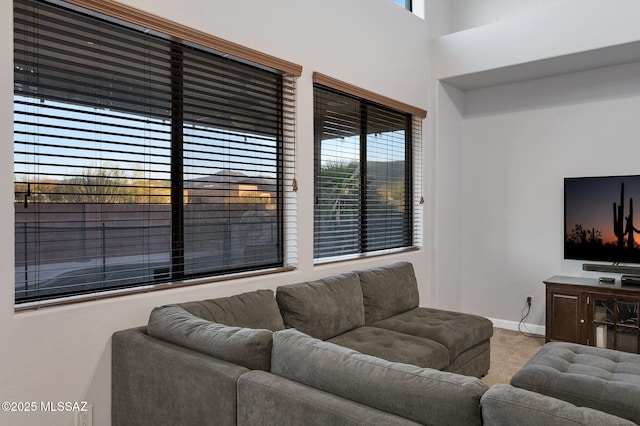 carpeted living room with baseboards