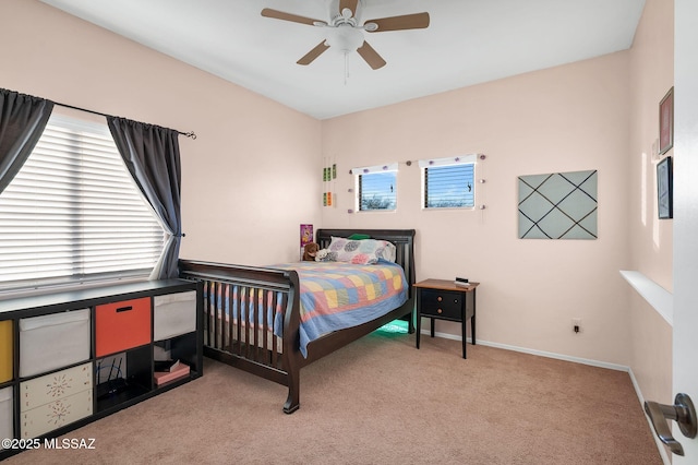 bedroom with light colored carpet, a ceiling fan, and baseboards