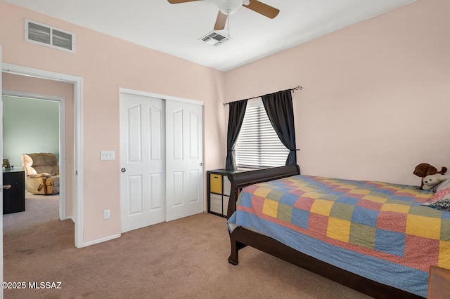 bedroom with visible vents, a closet, a ceiling fan, and light carpet