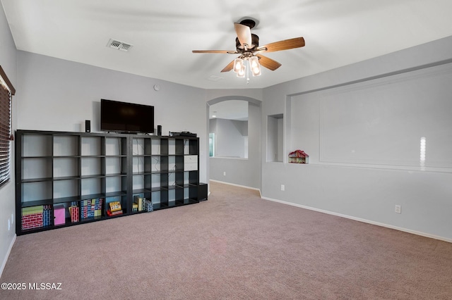 rec room with arched walkways, carpet flooring, baseboards, visible vents, and a ceiling fan